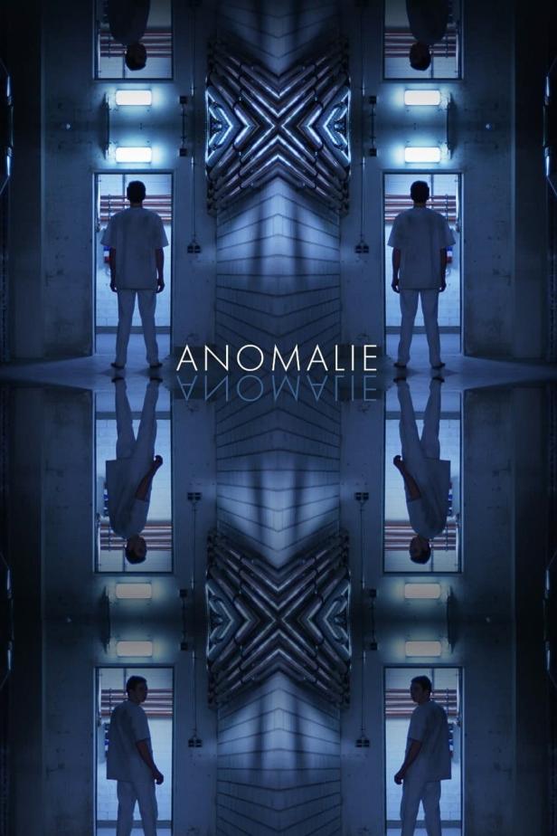 Ein Mann in weißer Kleidung steht in einem bläulich beleuchteten Raum mit dem Schriftzug „Anomalie“.