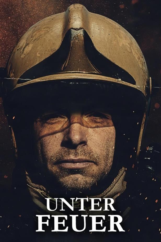 Ein Feuerwehrmann mit Helm blickt ernst in die Kamera.