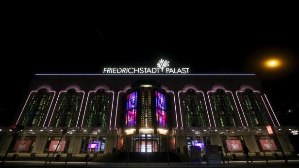 Der Friedrichstadt-Palast in Berlin ist nachts hell erleuchtet.