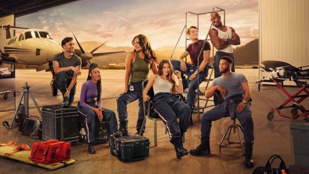 Das Team von „SkyMed“ posiert vor einem Flugzeug in einem Hangar.