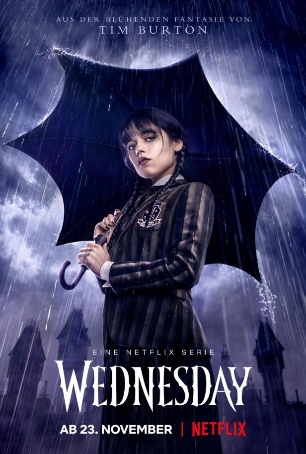 Jenna Ortega als Wednesday Addams im Regen mit einem Regenschirm.