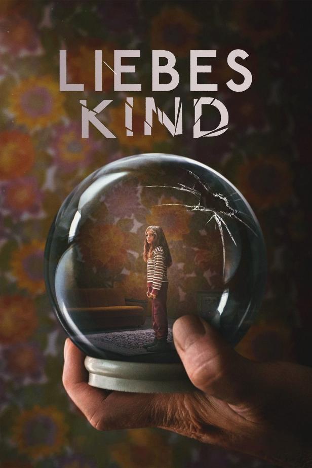 Das Poster für „Liebes Kind“ zeigt ein Mädchen in einer zerbrochenen Schneekugel, die von einer Hand gehalten wird.