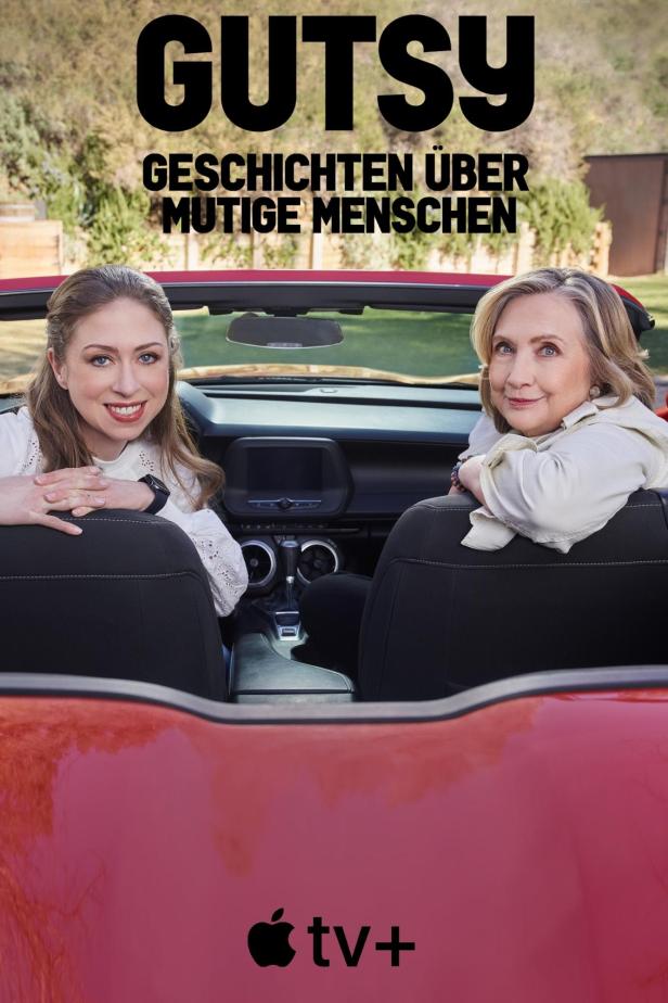Chelsea und Hillary Clinton sitzen in einem roten Cabrio für die Apple TV+ Serie „Gutsy“.
