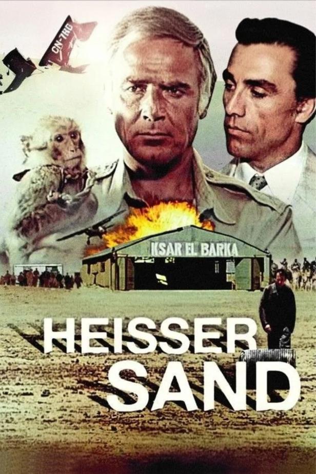 Das Filmplakat für „Heisser Sand“ zeigt zwei Männer, einen Affen und eine Explosion vor einem Hangar.