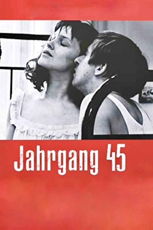 Das Filmplakat für „Jahrgang 45“ zeigt ein Paar in Schwarzweiß vor rotem Hintergrund.