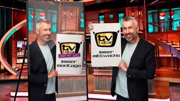 Zwei Männer präsentieren Schilder mit dem „TV total“-Logo und Sendehinweisen.