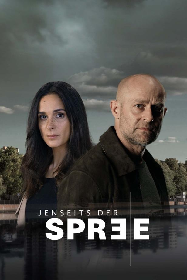 Das Filmplakat für „Jenseits der Spree“ zeigt zwei Ermittler vor einer Flusslandschaft.