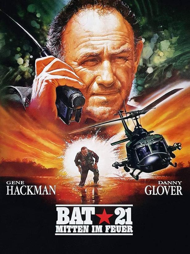 Das Filmplakat für „Bat 21 – Mitten im Feuer“ zeigt Gene Hackman mit einem Funkgerät und einen Hubschrauber.