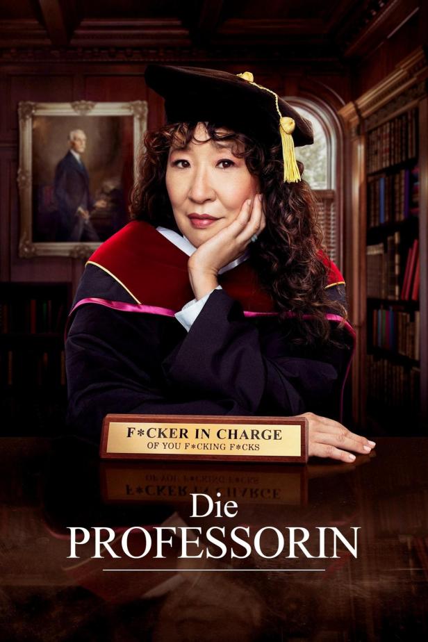 Sandra Oh als „Die Professorin“ in akademischer Kleidung vor einem Bücherregal.