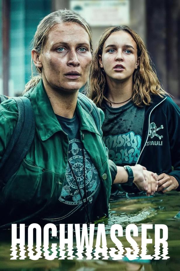 Zwei Frauen stehen im Wasser, möglicherweise nach einer Überschwemmung.