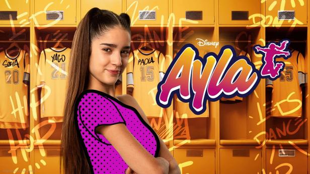 Porträt einer jungen Frau vor gelben Spinden mit Trikots für „Ayla“.