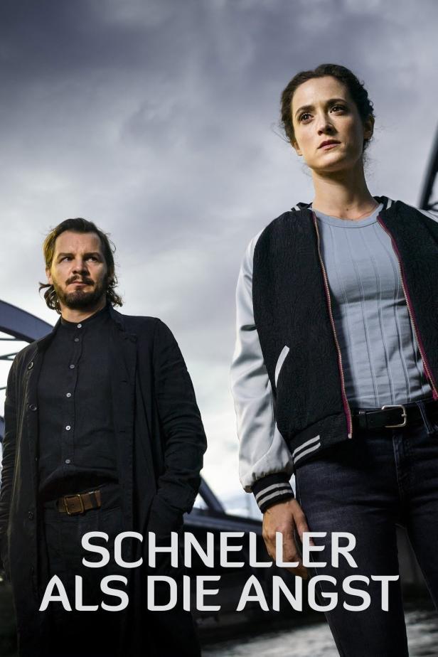 Ein Mann und eine Frau stehen vor einem grauen Himmel; Filmposter für „Schneller als die Angst“.