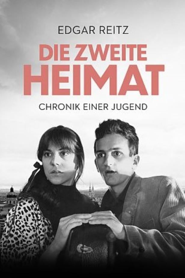 Das Filmplakat für Edgar Reitz' „Die zweite Heimat – Chronik einer Jugend“ zeigt ein junges Paar vor einer Stadtkulisse.