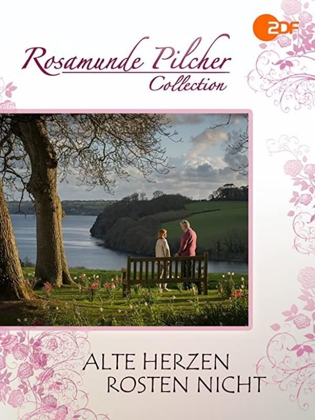 Ein älteres Paar sitzt auf einer Bank mit Blick auf einen See in „Alte Herzen rosten nicht“ von Rosamunde Pilcher.