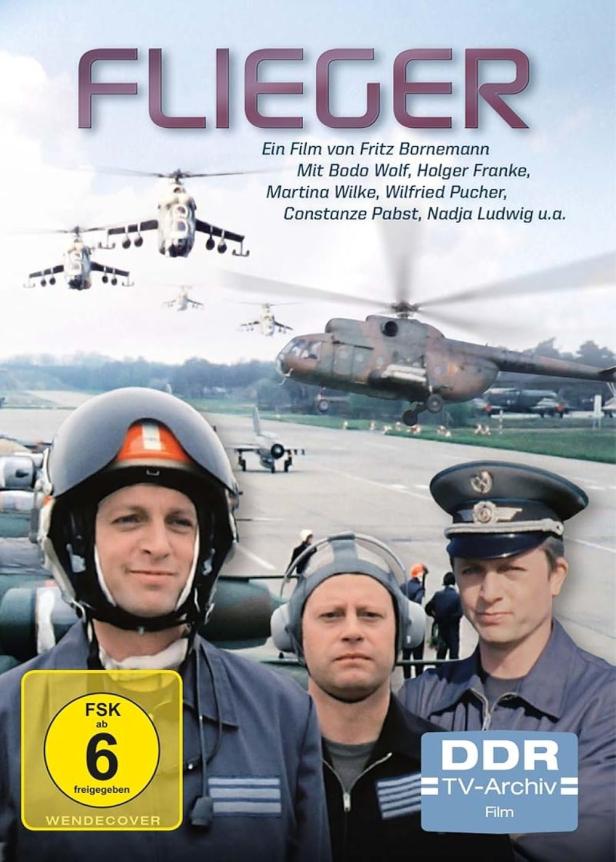 Das Filmplakat für „Flieger“ zeigt Hubschrauber und Piloten auf einem Flugfeld.