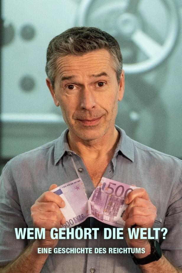 Ein Mann zerreißt zwei 500-Euro-Scheine vor einem Tresorraum, Titel: „Wem gehört die Welt? Eine Geschichte des Reichtums“.