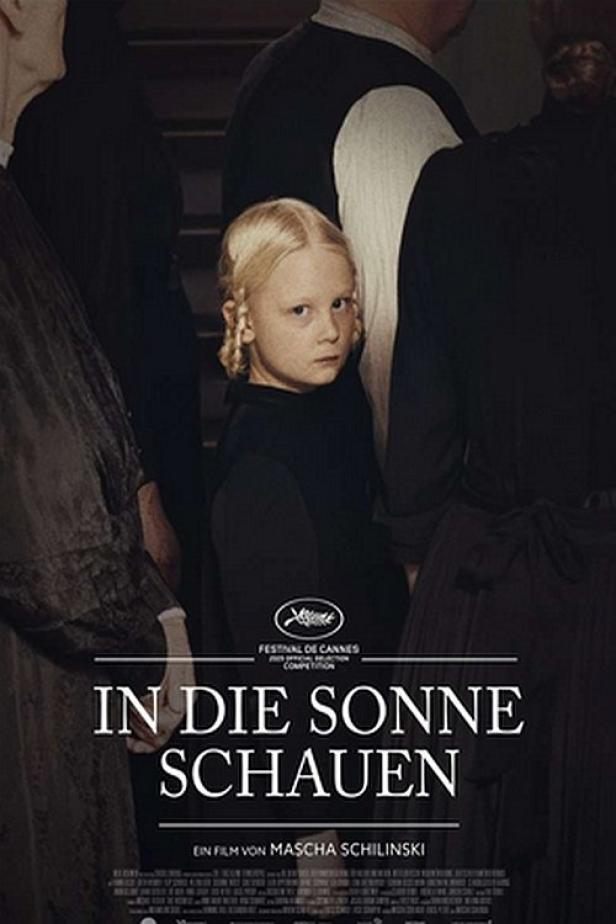 Das Filmplakat für „In die Sonne schauen“ zeigt ein blondes Mädchen inmitten einer Gruppe von Menschen.