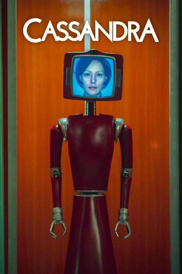 Ein roter Roboter mit einem Fernsehbildschirm als Kopf, der den Titel „Cassandra“ trägt.
