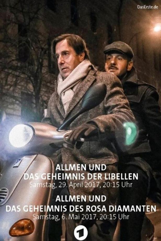 Zwei Männer, vermutlich aus „Allmen und das Geheimnis der Libellen“, fahren auf einem Motorroller.