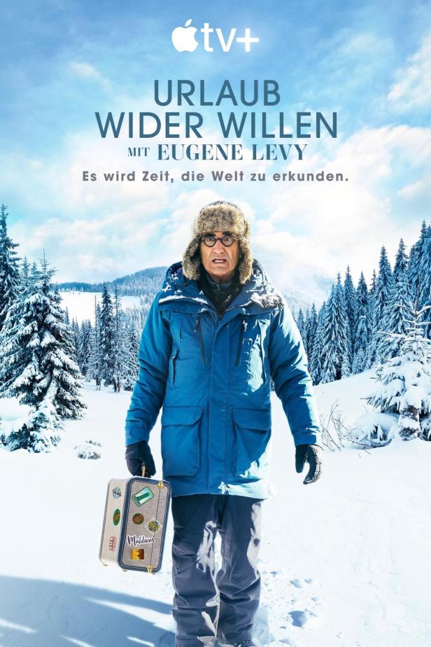 Eugene Levy steht mit einem Koffer im Schnee, beworben für die Serie „Urlaub wider Willen“.