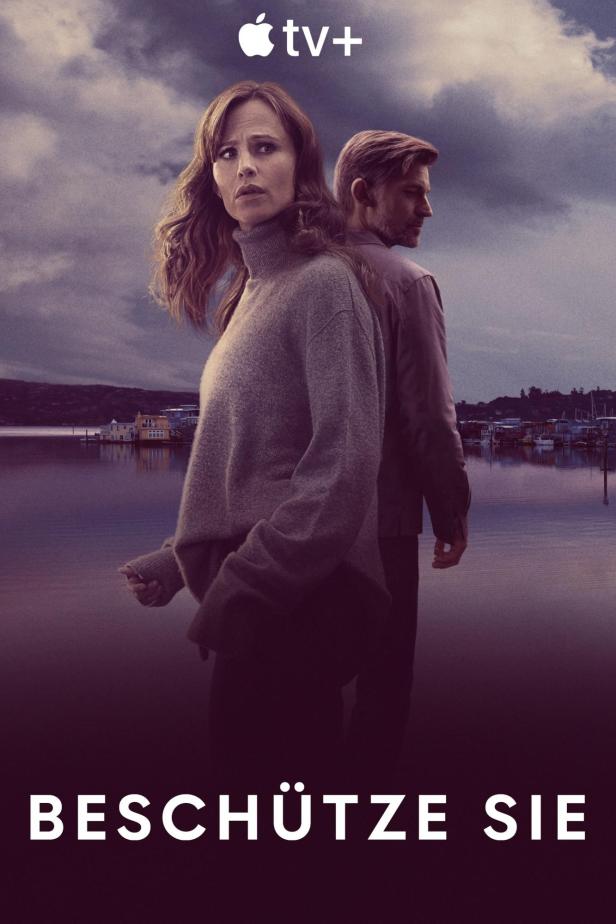 Ein Mann und eine Frau stehen vor einem See, im Hintergrund Häuser auf dem Wasser.