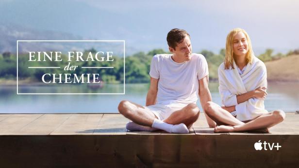 Ein Mann und eine Frau sitzen am See, im Hintergrund das Logo von „Eine Frage der Chemie“.