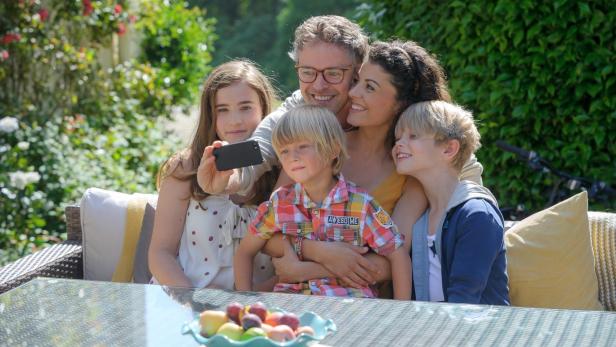 Eine Familie macht ein Selfie im Garten.