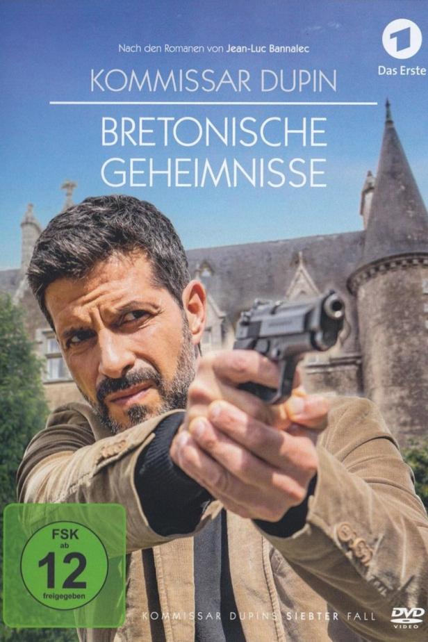 Das Cover von „Kommissar Dupin – Bretonische Geheimnisse“ zeigt Kommissar Dupin mit einer Waffe vor einem Schloss.