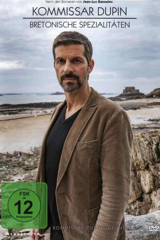 Das Cover von „Kommissar Dupin – Bretonische Spezialitäten“ zeigt Kommissar Dupin vor einer bretonischen Küstenlandschaft.