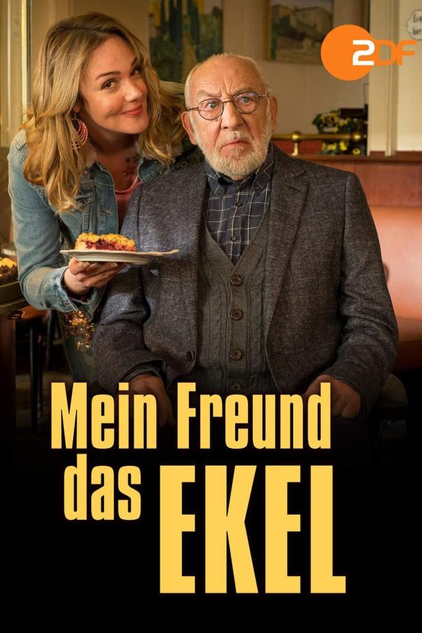 Ein älterer Mann und eine jüngere Frau mit einem Stück Kuchen, im Hintergrund der Titel „Mein Freund das Ekel“.