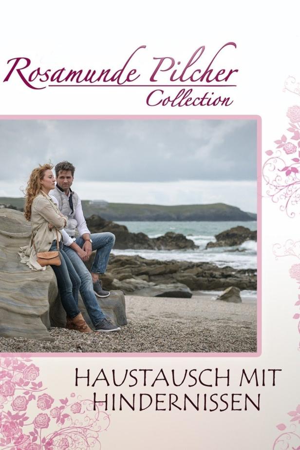 Cover von Rosamunde Pilchers „Haustausch mit Hindernissen“ mit einem Paar am Strand.
