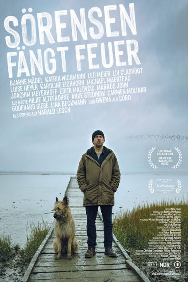 Das Filmplakat zu „Sörensen fängt Feuer“ zeigt einen Mann mit Hund auf einem Steg am Wasser.