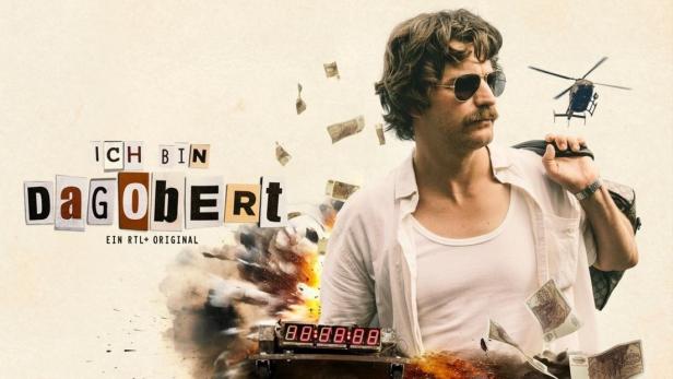 Ein Mann mit Sonnenbrille und Schnurrbart vor einem Hubschrauber und dem Schriftzug „Ich bin Dagobert“.