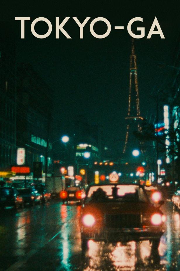 Nachts in Tokio: Autos fahren auf einer nassen Straße, im Hintergrund der Tokyo Tower.