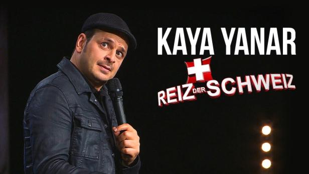 Kaya Yanar auf der Bühne mit dem Titel „Reiz der Schweiz“ im Hintergrund.