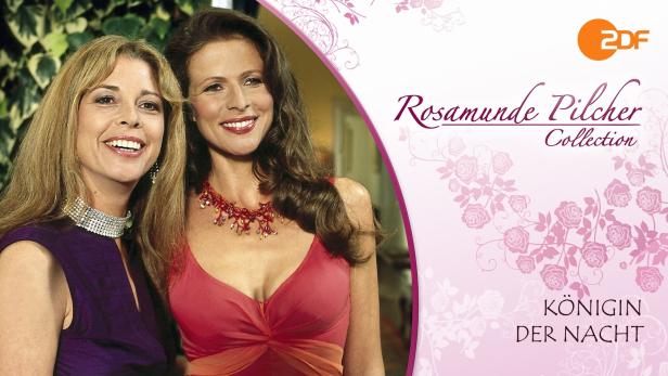Zwei lächelnde Frauen vor dem Cover der Rosamunde Pilcher Collection „Königin der Nacht“.