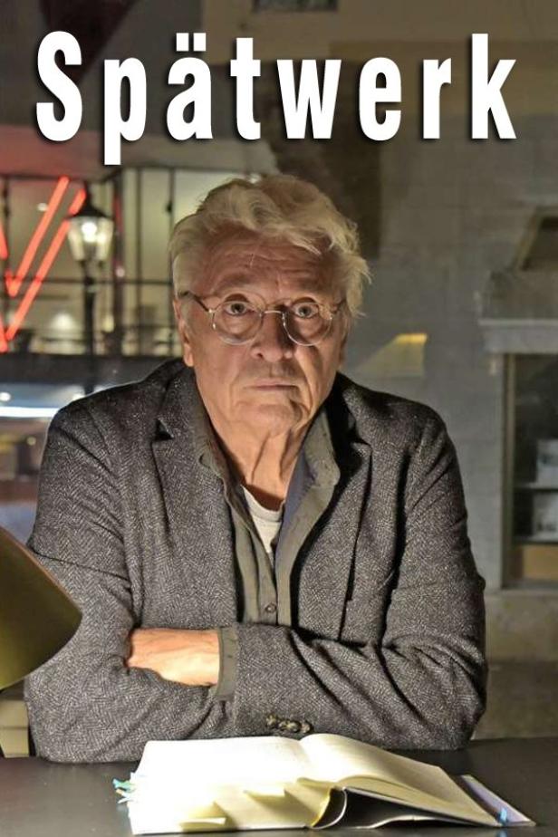 Ein Mann sitzt an einem Tisch mit einem Buch, im Hintergrund der Titel „Spätwerk“.