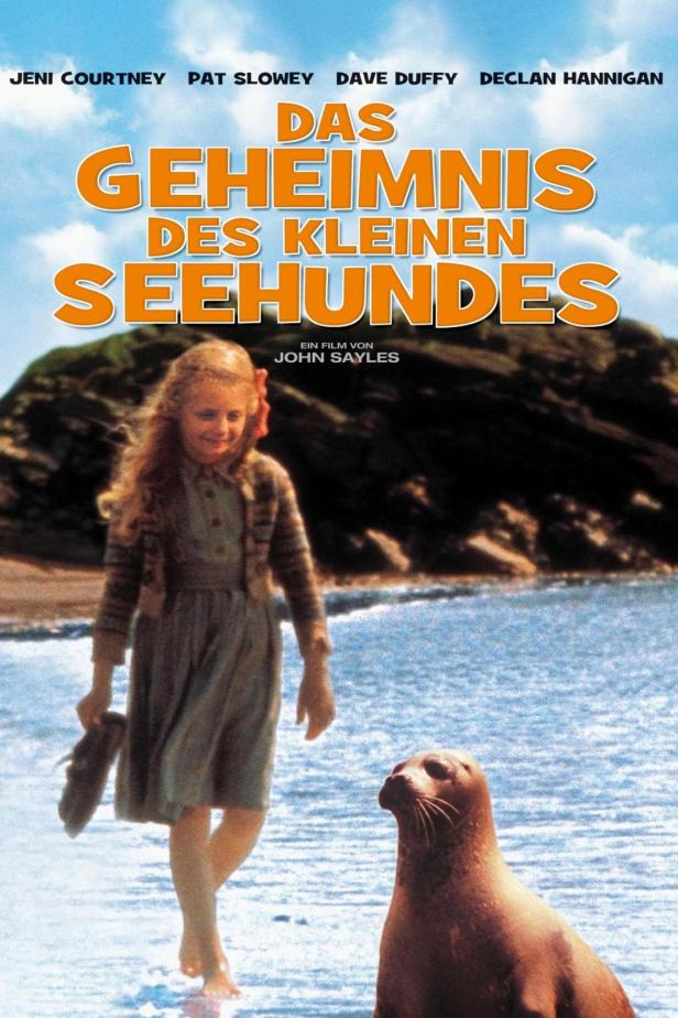 Das Filmplakat für „Das Geheimnis des kleinen Seehundes“ zeigt ein Mädchen und einen Seehund am Strand.