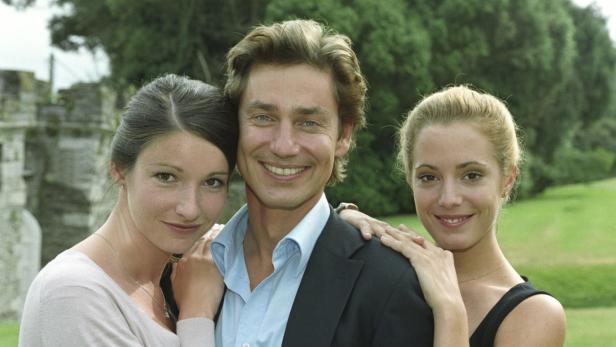 Ein Mann posiert mit zwei Frauen im Freien für ein Foto.