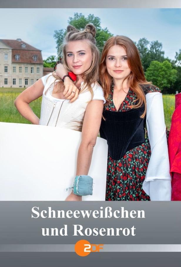 Zwei junge Frauen in historischen Kostümen posieren vor einem Schloss.