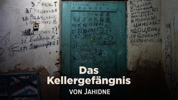 Eine beschriftete Tür und Wände in einem Kellergefängnis.