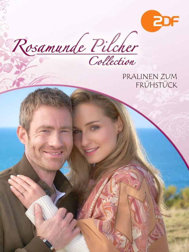 Das Cover von Rosamunde Pilchers „Pralinen zum Frühstück“ mit einem Paar vor dem Meer.