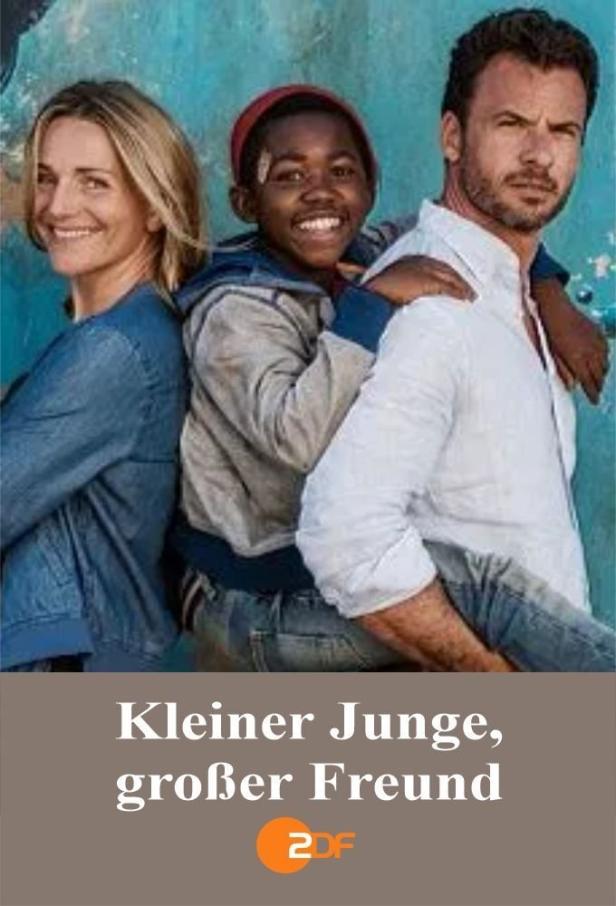 Eine Frau, ein Junge und ein Mann stehen vor einer blau gestrichenen Wand.
