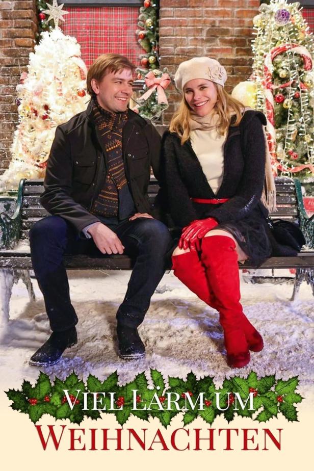 Ein Mann und eine Frau sitzen vor weihnachtlicher Kulisse auf einer Bank.