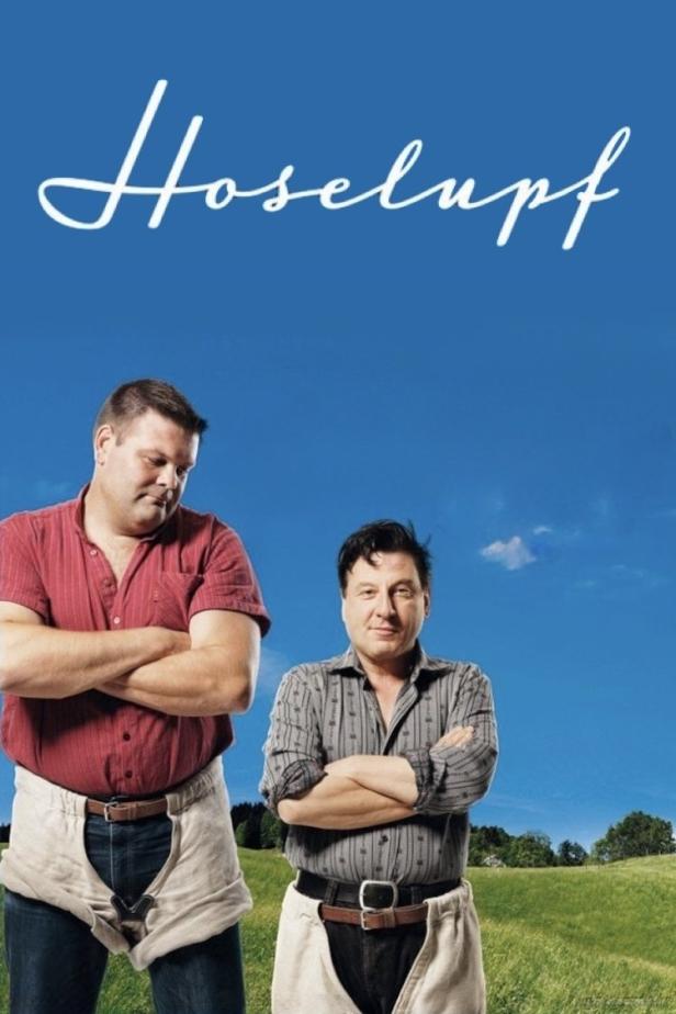Das Filmplakat für „Hoselupf“ zeigt zwei Männer in traditioneller Schweizer Kleidung vor blauem Himmel.