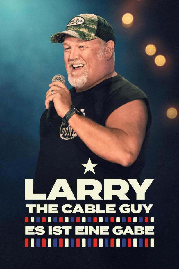 Larry the Cable Guy steht mit einem Mikrofon auf der Bühne.