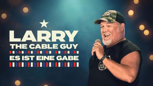 Larry the Cable Guy hält ein Mikrofon und tritt auf einer Bühne auf.