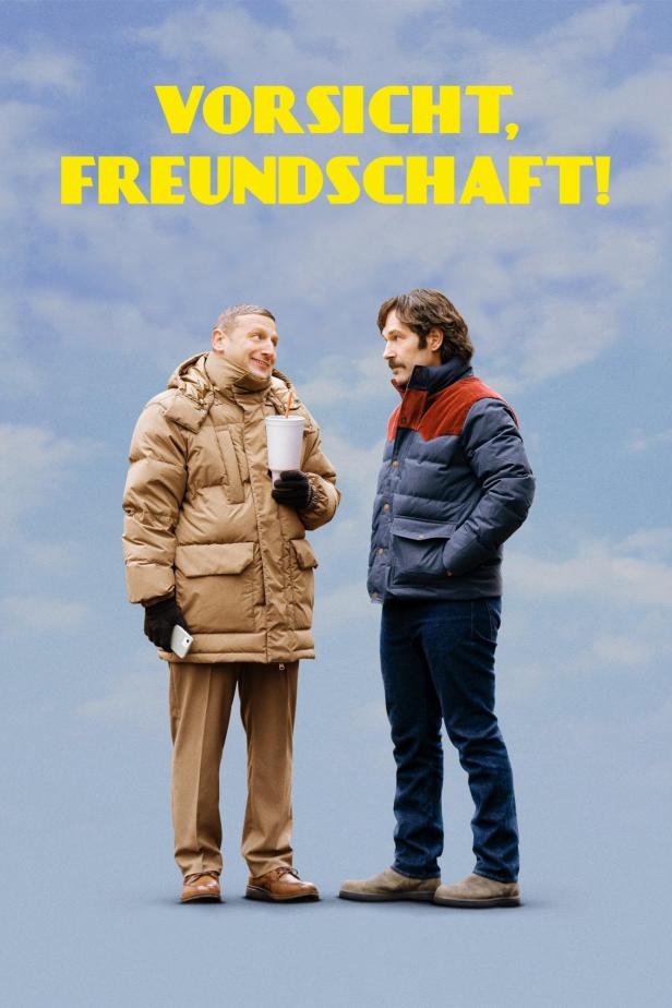 Das Filmplakat für „Vorsicht, Freundschaft!“ zeigt zwei Männer in Winterkleidung vor blauem Himmel.