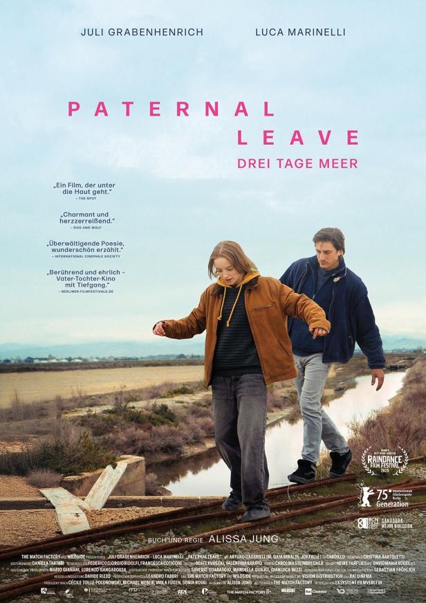 Das Filmplakat für „Paternal Leave“ zeigt eine junge Frau und einen Mann, die auf Bahngleisen in Richtung Horizont gehen.