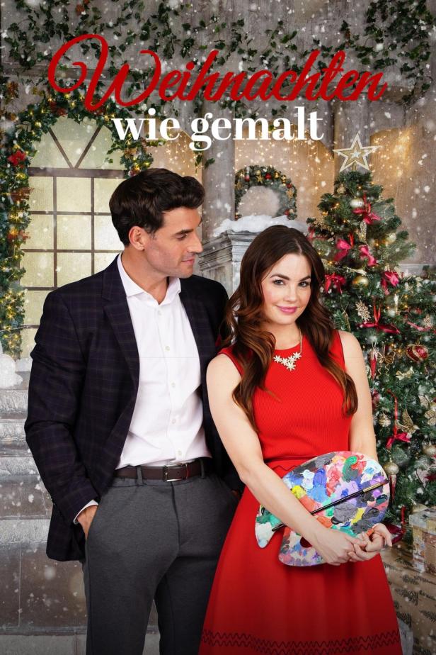 Ein Mann und eine Frau vor einem Weihnachtsbaum, sie hält eine Farbpalette in der Hand.